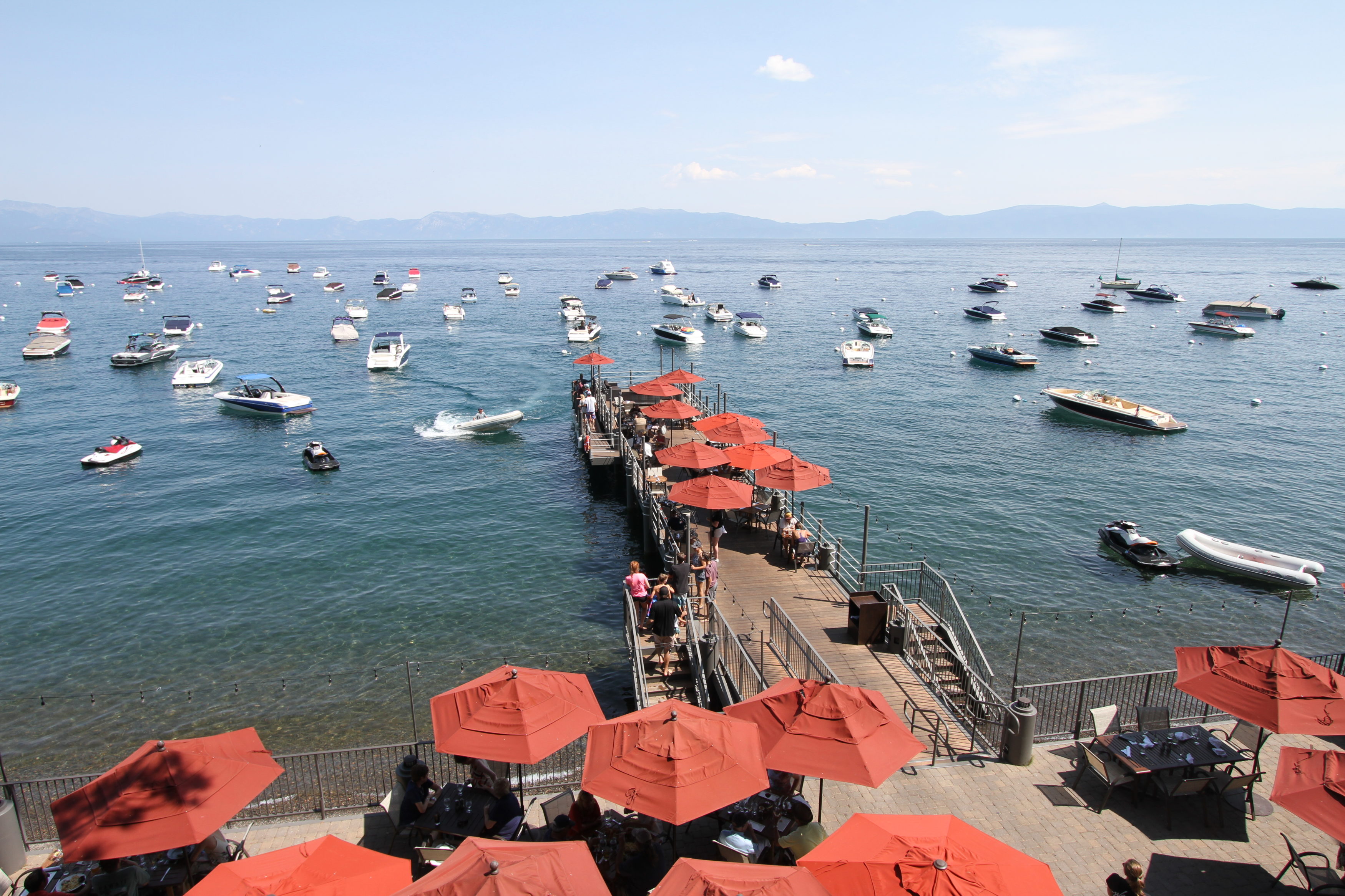 West shore cafe pier over looking lake tahoe with boats on buoys in the background.