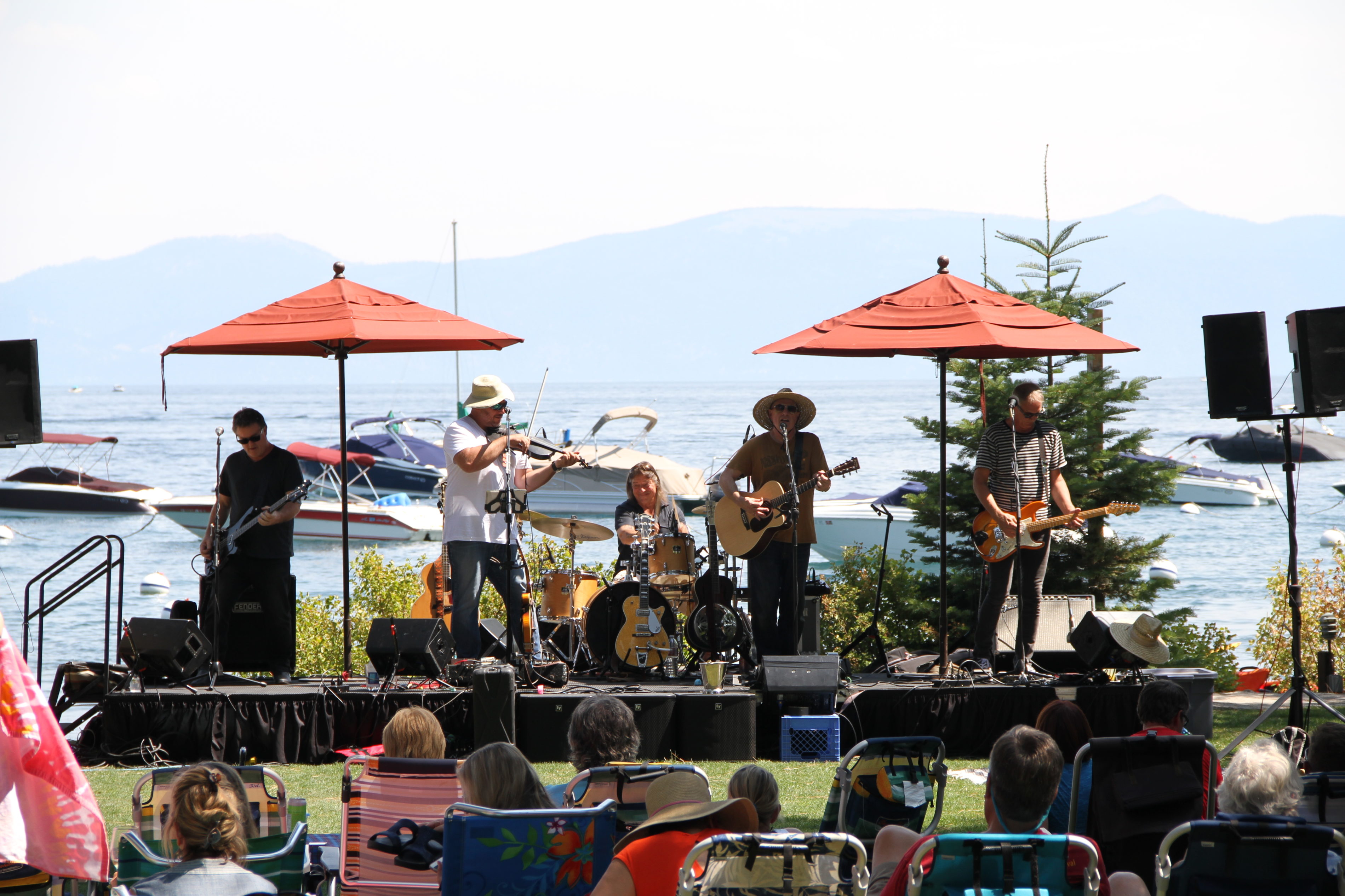 A live band plays music in front of Lake Tahoe on the West Shore Cafe Lawn.