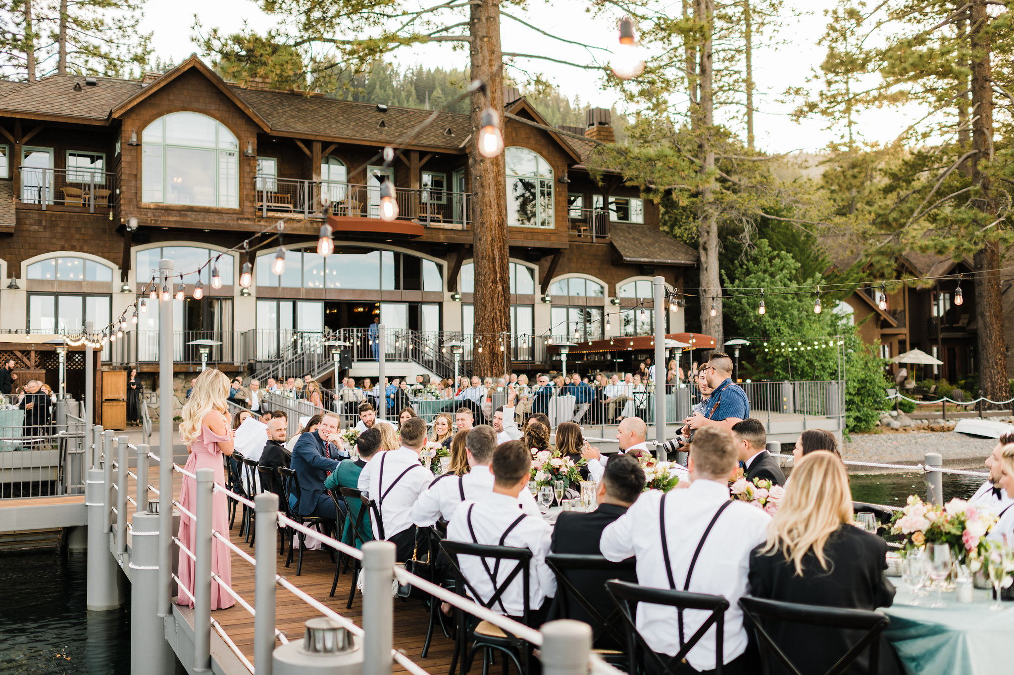 Guests enjoy dinner on the West Shore Cafe Pier and Patio over looking Lake Tahoe during a wedding