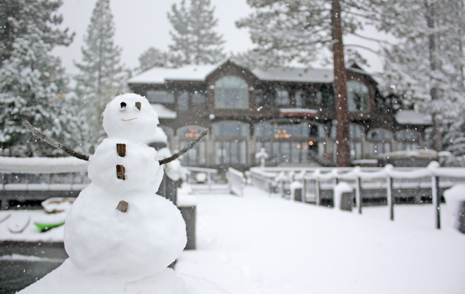 Snowman on a pier with west shore cafe in the background