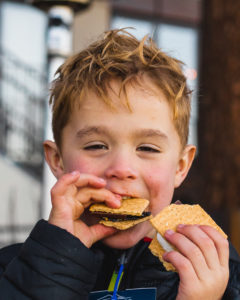 Boy eating smores on patio of West Shore Cafe