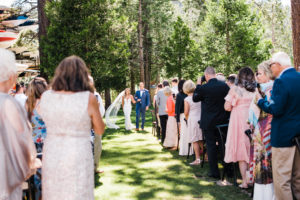 A bride and father walk down the aisle together on the West Shore Cafe Lawn. Custock Photography