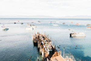 An overhead view of people enjoying dinner on the West Shore Cafe Pier overlooking Lake Tahoe.