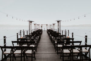 The West Shore Cafe Pier set with chairs and an alter for a wedding. Lake Tahoe is in the background. Kay Kroshus Photography