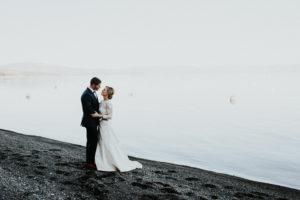 A bride and groom stare into each others eyes on the beach at Lake Tahoe.Kay Kroshus Photography